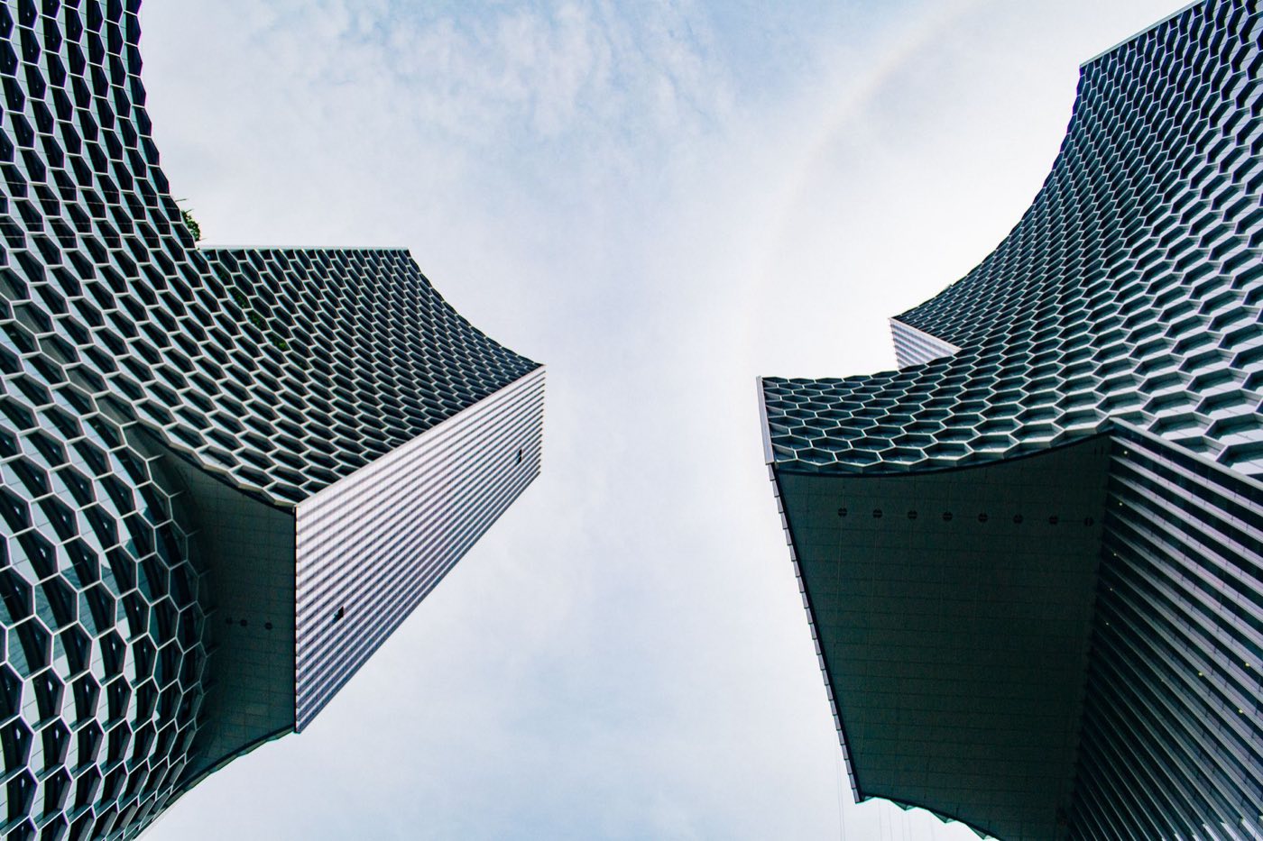 Two modern towers with honeycomb facades, seen from below